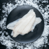 Fresh raw fish fillet on black plate over crushed ice, ready for cooking or packaging.