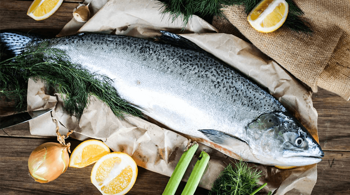 Whole salmon with dill, fennel & lemon wedge.