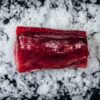 Frozen tuna loin on crushed ice, premium sashimi-grade cut for grilling, searing or sushi.